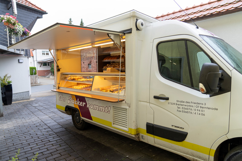 Verkaufswagen der Bäckerei Fütterer mit geöffneter Auslage im Dorf